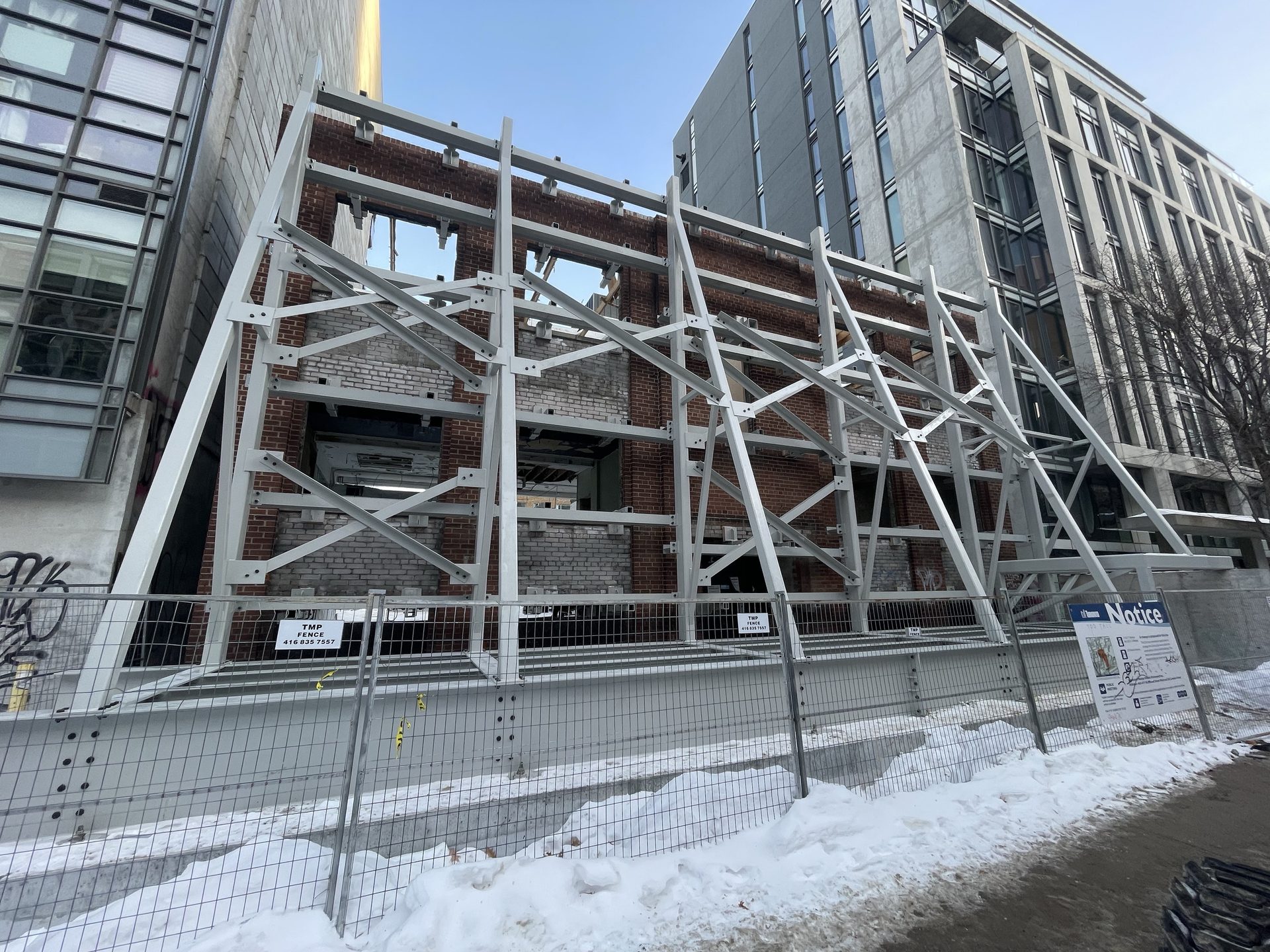 Extensive structural steel shoring system supporting a retained heritage brick facade
