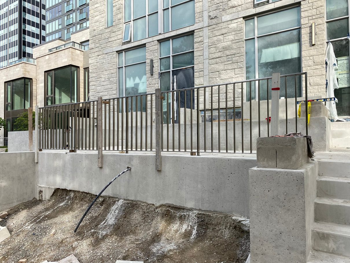 Aluminum railing on a stone building facade with concrete steps