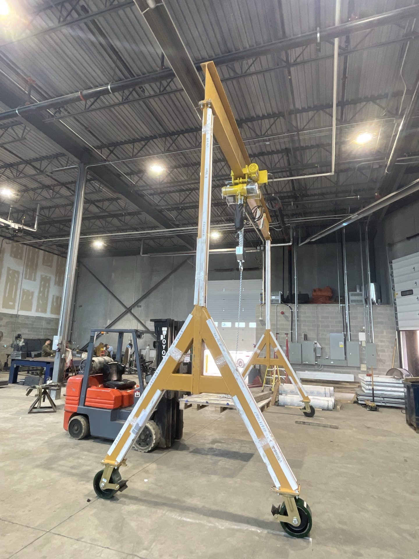 Custom fabricated mobile gantry crane with hoist in the shop